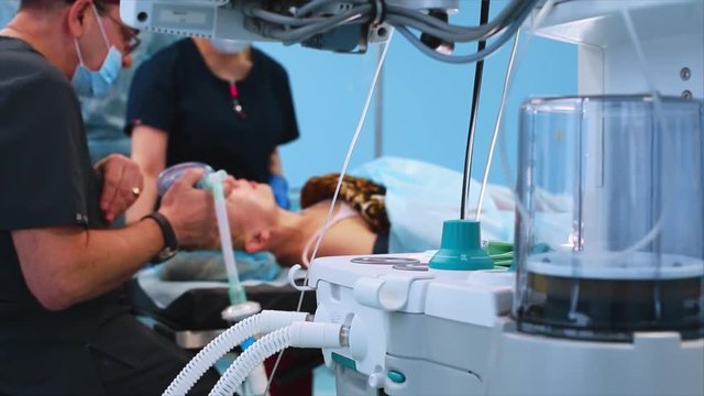 The operating room, the preparation of the patient for the operation, the anesthesiologist introduces the patient into anesthesia. View from behind the ventilator