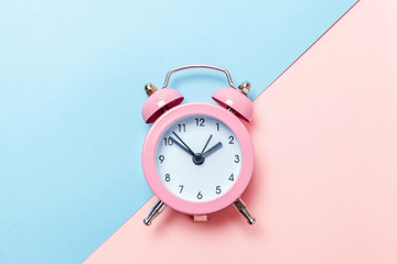 Ringing twin bell vintage classic alarm clock Isolated on blue pink pastel colorful trendy background. Rest hours time of life good morning night wake up awake concept. Flat lay top view copy space