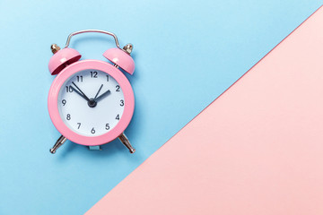 Ringing twin bell vintage classic alarm clock Isolated on blue pink pastel colorful trendy background. Rest hours time of life good morning night wake up awake concept. Flat lay top view copy space