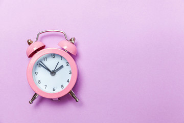 Ringing twin bell vintage classic alarm clock Isolated on purple violet pastel colourful...