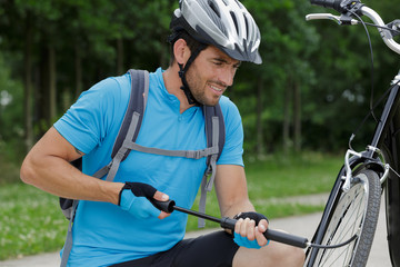 man pumping bicycle wheel