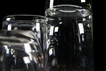 Naklejka na ściany i meble Close up of three different empty shot glasses on black background.