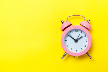 Ringing twin bell vintage classic alarm clock Isolated on yellow colourful trendy modern...