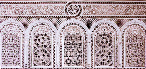 Beautiful complex exquisite carving on the plastered white walls of the Bahia Palace in the southeastern part of the medina of Marrakesh. Morocco Africa