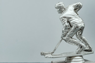  Shining silver metal statue of ice hockey in front gates with dramatic light and dust particles in...