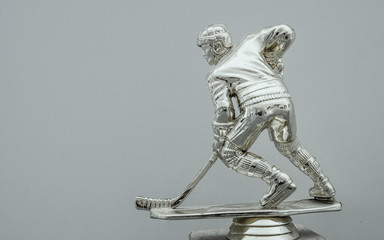  Shining silver metal statue of ice hockey in front gates with dramatic light and dust particles in...