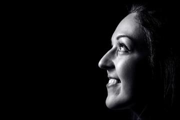 Portrait of young woman isolated on black background, close up.