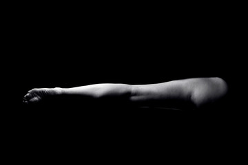 Fototapeta na wymiar Close up of one woman's leg isolated on black background.