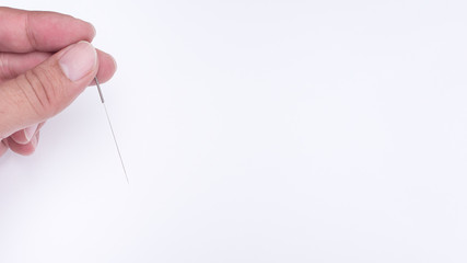 Hand holding acupuncture needle Used for Chinese medicine.