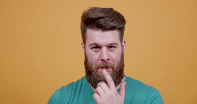 Funny hipster with beard making silly and funny faces. Man having fun and shows silly dumb faces to a kid to entertain.