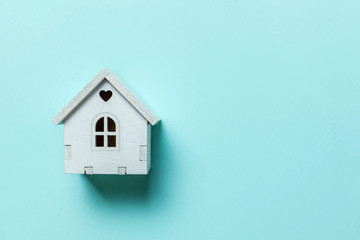 Obraz na płótnie Canvas Simply design with miniature white toy house isolated on blue pastel colorful trendy background. Mortgage property insurance dream home concept. Flat lay top view copy space