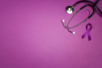 Purple epilepsy awareness ribbon with stethoscope and copy space on a purple background. World epilepsy day.