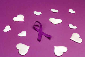 Purple epilepsy awareness ribbon wit white heats on a purple background. World epilepsy day.
