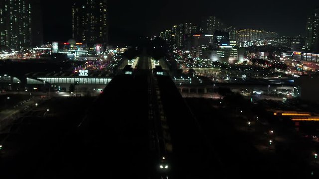High-speed train passing through the station, night scenery, drone follow shot