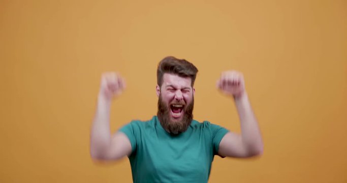 A man is very happy to win at a game and cheers and dances. Very emotional young man after he finds out he won money.