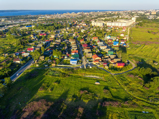 Evening aerial panorama of green city on lake