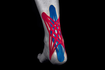 Medical taping for Achilles tendon isolated on black background.