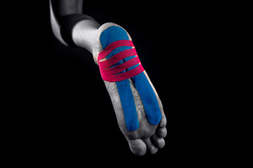 Medical taping for calcaneal spur and plantar fasciitis treatment isolated on black background.