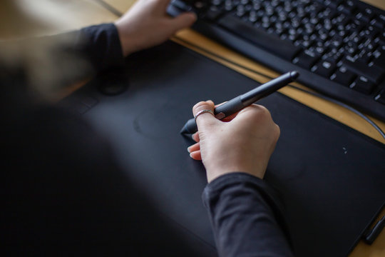 young woman designer using wacom stylus tablet for illustrating, retouching and animation