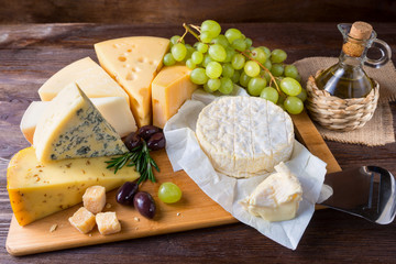 Fototapeta Cheese plate served with grapes on a wooden background obraz