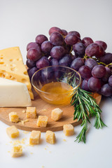 Cheese selection, honey and grape isolated on white background