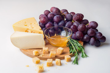 Cheese selection, honey and grape isolated on white background