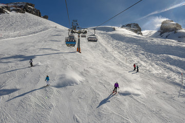 Fototapeta na wymiar People skiing and going up the mountain by chairlift at Engelberg on the Swiss alps
