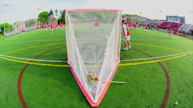This is a Time Lapse shot of a Lacrosse game during their warmups. This shot is taken from behind the Goal/Net as players practice.