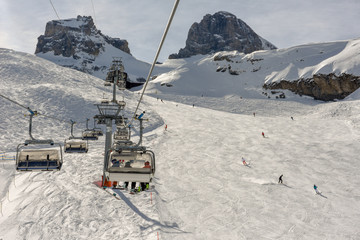 People skiing and going up the mountain by chairlift at Engelberg on the Swiss alps