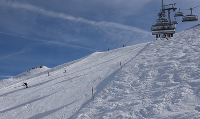 People skiing and going up the mountain by chairlift at Engelberg on the Swiss alps