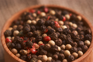 bowl of various pepper peppercorns seeds mix on table rastic style background
