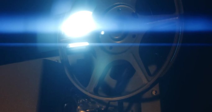 Film runs through an 8mm projector. Pan across reel.