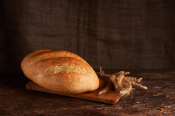 Bakery - gold rustic crusty loaves of bread and buns on black chalkboard background. Still life captured from above