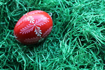 Handbemaltes rotes Osterei im Gras