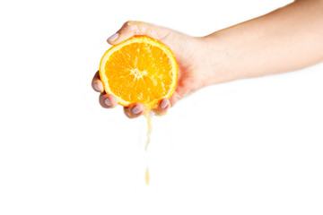 female hand crushes orange on white background