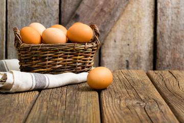 basket of eggs, old weathered wooden background