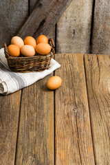 basket of eggs, old weathered wooden background