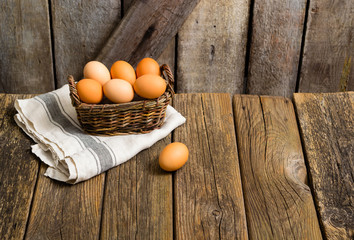 basket of eggs, old weathered wooden background