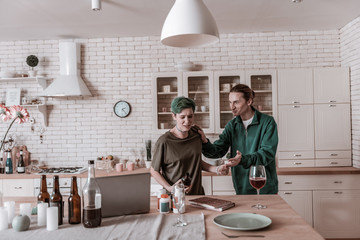 Loving husband pushing her wife away from table with alcohol