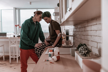 Husband wearing green jacket supporting his stressed wife