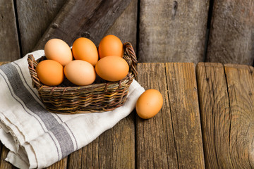 basket of eggs, old weathered wooden background