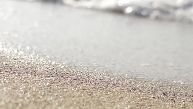 Waves on sand close up