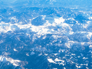 above view of tops of Alps mountain from airplane