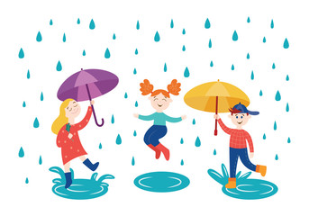 Cheerful children playing and jumping under umbrella in rainy weather outdoors in autumn.
