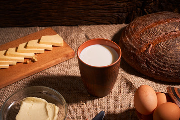 Assorted dairy products milk, cheese, butter rustic still life on table