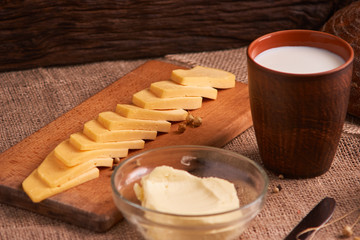Butter and chees and milk for breakfast, over rustic wooden background with copy space. Morning breakfast