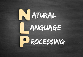 Wooden alphabets building the word NLP - Natural Language Processing acronym on blackboard