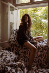 Obraz premium Junge Frau auf Fensterbrett