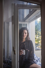 Fototapeta na wymiar Junge Frau auf Fensterbrett