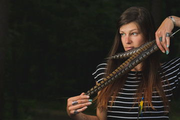 Gypsy style young woman wearing tribal jewelry. Woman posing oriental costume in a dark forest.